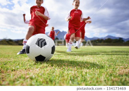 Running, closeup and sports with children and soccer ball on field for training, competition and fitness. Teamwork, summer and action with football player on pitch for goals, energy and kids game Running, closeup and sports with children and soccer ball on field for training, competition and fitness. Teamwork, summer and action with football player on pitch for goals, energy and kids game 134173469