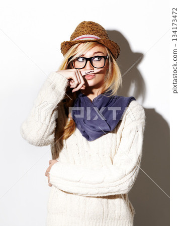 Hipster, isolated portrait and girl with moustache on index finger, nerd glasses and fun pose on studio white background. Young woman, modern fashion and mustache joke or goofy, weird and finger Hipster, isolated portrait and girl with moustache on index finger, nerd glasses and fun pose on studio white background. Young woman, modern fashion and mustache joke or goofy, weird and finger 134173472
