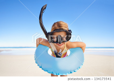 Portrait, beach and child with goggles and inflatable gear for swimming, summer holiday and happy outdoor adventure. Face of kid excited standing by the ocean or sea water excited for vacation 134173541