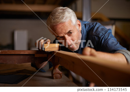 Senior carpenter, wood sanding and man with precision on building construction and architecture project. Home improvement, handyman and work of a mature male employee with carpentry tool for woodwork 134173545
