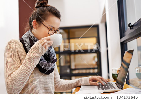 Remote work, woman drinking coffee and laptop for freelance writer at cafe store. Social media or networking, reading emails and female student or content creator on mobile device in restaurant Remote work, woman drinking coffee and laptop for freelance writer at cafe store. Social media or networking, reading emails and female student or content creator on mobile device in restaurant 134173649