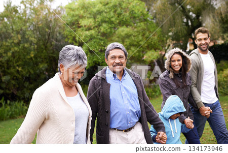 Big family, smile and holding hands in park with kid, parents and grandparents with love, care or happiness. Group, senior people and child with bonding, walk and freedom in garden, nature or holiday 134173946