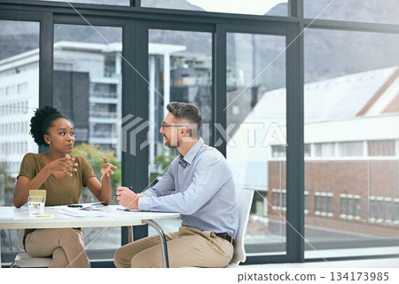 Business people, meeting and talking or planning in an office with city building background. A man and woman together at table for diversity, brainstorming and collaboration or partnership discussion Business people, meeting and talking or planning in an office with city building background. A man and woman together at table for diversity, brainstorming and collaboration or partnership discussion 134173985