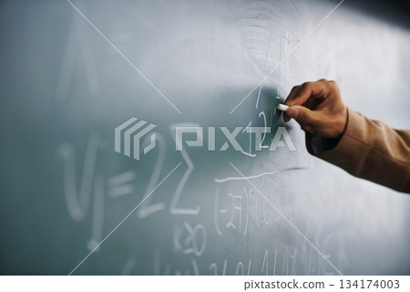 Closeup, hand and writing on a blackboard, formula and teaching with system, process and geek. Zoom, person and teacher with chalk, learning and maths equation with calculation, research or education 134174003