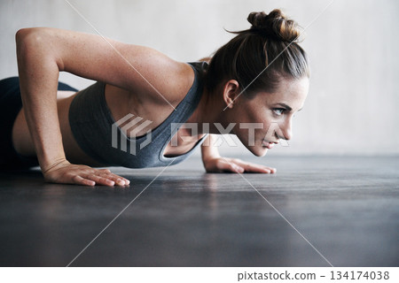 Fitness, pushup and woman on a floor for training, cardio and endurance at gym. Lifting, exercise and female athlete at a health center for core, strength and ground workout with determined mindset 134174038