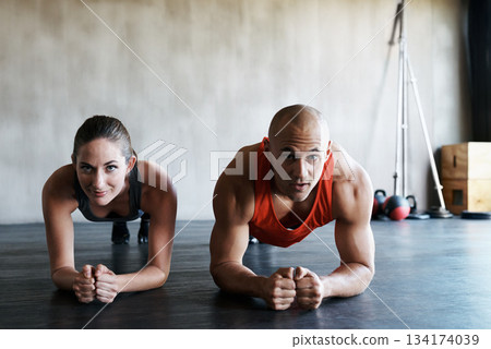 Gym floor, portrait and people doing plank challenge, fitness club commitment or core strength building. Balance, teamwork and athlete man, woman or partnership team concentrate on muscle workout Gym floor, portrait and people doing plank challenge, fitness club commitment or core strength building. Balance, teamwork and athlete man, woman or partnership team concentrate on muscle workout 134174039