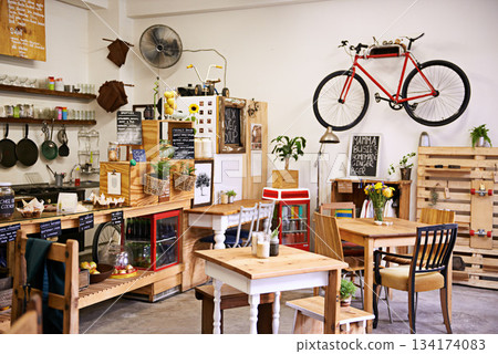 Space, interior and empty coffee shop with table, chairs and furniture or small business, bistro and cafe with unique design and style. Background, creative startup and food store with bike on wall Space, interior and empty coffee shop with table, chairs and furniture or small business, bistro and cafe with unique design and style. Background, creative startup and food store with bike on wall 134174083