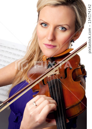 Sheet music, violin and portrait of woman in studio, professional orchestra musician on white background. Art, musical creativity and classical performance, face of concert violinist with instrument. 134174142