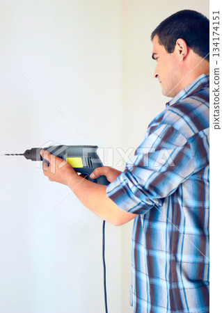 Wall drill, home and man with renovation, construction work or house improvement for maintenance, repair or builder project. Contractor, handyman or male technician with electric tools for drilling Wall drill, home and man with renovation, construction work or house improvement for maintenance, repair or builder project. Contractor, handyman or male technician with electric tools for drilling 134174151