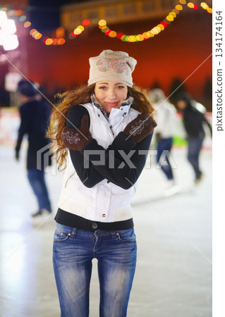Woman, ice rink and portrait on cold night with self hug, training and exercise on winter holiday. Young girl, skate and freezing body with warm clothes for mistake, outdoor and regret on vacation 134174164