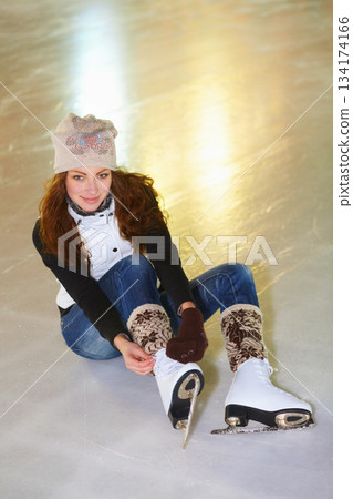 Portrait, ice skating and woman tie shoes on rink to start fitness, exercise and workout at night. Skater, happiness and female person tying skates for winter training, getting ready and top view. Portrait, ice skating and woman tie shoes on rink to start fitness, exercise and workout at night. Skater, happiness and female person tying skates for winter training, getting ready and top view. 134174166