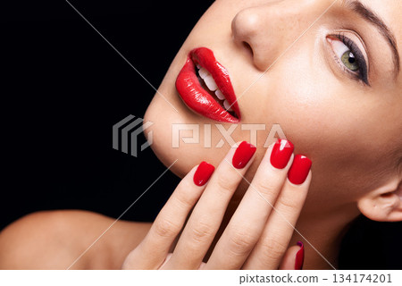 Beauty, makeup and woman with red lipstick and nails in a studio with a self care pamper treatment. Cosmetic, portrait and half face closeup of female model with a facial routine by black background. 134174201
