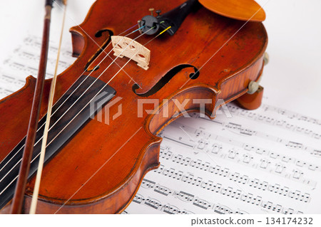 Sheet, music and classical with violin on paper for orchestra, vintage and antique instrument. Notes, retro art and culture with closeup of wooden fiddle for symphony, sound and theatre performance Sheet, music and classical with violin on paper for orchestra, vintage and antique instrument. Notes, retro art and culture with closeup of wooden fiddle for symphony, sound and theatre performance 134174232