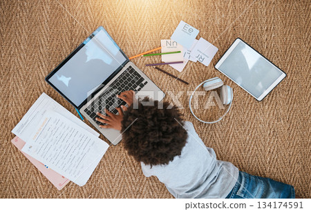 Online education, laptop and child on floor for e learning, language translation and typing on kids website. Kid relax on carpet with computer, headphones and digital tech for home development above Online education, laptop and child on floor for e learning, language translation and typing on kids website. Kid relax on carpet with computer, headphones and digital tech for home development above 134174591