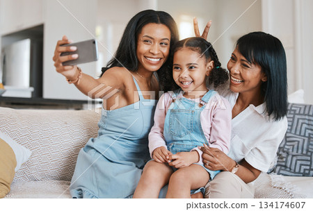 Peace sign selfie, grandmother and kid with mother in home living room, bonding or having fun. Family, smile and girl with grandma and mama, care or taking pictures on sofa with v hand emoji together Peace sign selfie, grandmother and kid with mother in home living room, bonding or having fun. Family, smile and girl with grandma and mama, care or taking pictures on sofa with v hand emoji together 134174607