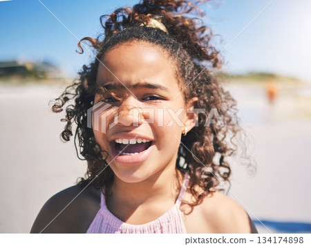 Child, beach and portrait in nature with a young girl and smile on summer holiday. Face, closeup and African female child at the sea on vacation feeling happy from the ocean and outdoor fun in sun Child, beach and portrait in nature with a young girl and smile on summer holiday. Face, closeup and African female child at the sea on vacation feeling happy from the ocean and outdoor fun in sun 134174898
