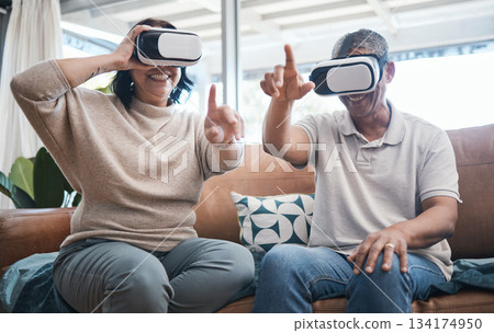 Senior couple, virtual reality and sofa in home living room with esports, metaverse or internet gaming with smile. Man, woman and vr with happiness, learning and futuristic goggles on lounge couch Senior couple, virtual reality and sofa in home living room with esports, metaverse or internet gaming with smile. Man, woman and vr with happiness, learning and futuristic goggles on lounge couch 134174950