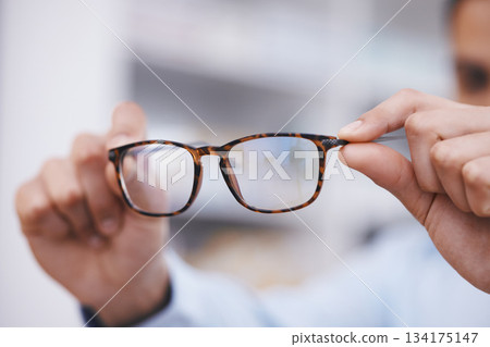 Optometry, hands and optician with glasses for choice, eyesight and frame decision. Giving, showing and a man holding prescription eyewear for a fitting, vision and service during a consultation Optometry, hands and optician with glasses for choice, eyesight and frame decision. Giving, showing and a man holding prescription eyewear for a fitting, vision and service during a consultation 134175147