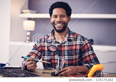Technician portrait, man and fixing electronics of computer hardware, soldering iron tools or tech repair. Maintenance, magnifying glass or electrical fix for happy African male working on technology Technician portrait, man and fixing electronics of computer hardware, soldering iron tools or tech repair. Maintenance, magnifying glass or electrical fix for happy African male working on technology 134175262