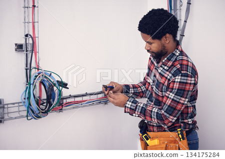Technician, black man and electrician checking cables, fixing faulty wires and server mechanic. Male employee, entrepreneur and engineer with tools, electrical and maintenance with handyman and focus Technician, black man and electrician checking cables, fixing faulty wires and server mechanic. Male employee, entrepreneur and engineer with tools, electrical and maintenance with handyman and focus 134175284