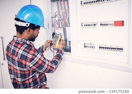 Electrician multimeter, electric switch box and man test cable system, wiring or measure voltage power supply. Quality control inspection, African repair person and technician electricity maintenance Electrician multimeter, electric switch box and man test cable system, wiring or measure voltage power supply. Quality control inspection, African repair person and technician electricity maintenance 134175289
