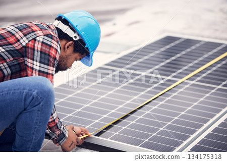 Technician, measuring tape and solar panel on rooftop for check, planning or renewable energy project. Black man, photovoltaic system and roof installation with focus, sustainable building or service 134175318