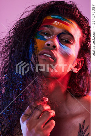 Creative, face paint and art with portrait of man in studio for beauty, self love and designer. Fantasy, neon and light with male model on pink background for makeup, colours and cosmetics Creative, face paint and art with portrait of man in studio for beauty, self love and designer. Fantasy, neon and light with male model on pink background for makeup, colours and cosmetics 134175387