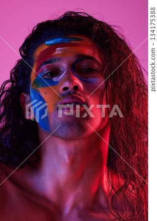 Beauty, cosmetics and portrait of man with paint for creative art, makeup and glow on studio background. Neon lighting, skincare and color on face of male model for fantasy, abstract and aesthetic Beauty, cosmetics and portrait of man with paint for creative art, makeup and glow on studio background. Neon lighting, skincare and color on face of male model for fantasy, abstract and aesthetic 134175388