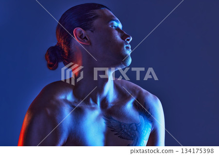 Man, sexy body and light in studio for art, fitness or beauty of a person on a blue background. Face, strong chest and fitness model with a tattoo, glow and creative motivation for aesthetic backdrop Man, sexy body and light in studio for art, fitness or beauty of a person on a blue background. Face, strong chest and fitness model with a tattoo, glow and creative motivation for aesthetic backdrop 134175398
