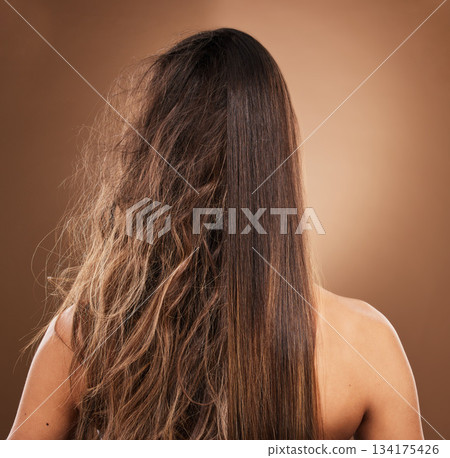Frizz, heat damage and hair of a woman isolated on a brown background in a studio. Back, salon treatment and lady showing results from keratin treatment, before and after a hairdresser procedure Frizz, heat damage and hair of a woman isolated on a brown background in a studio. Back, salon treatment and lady showing results from keratin treatment, before and after a hairdresser procedure 134175426