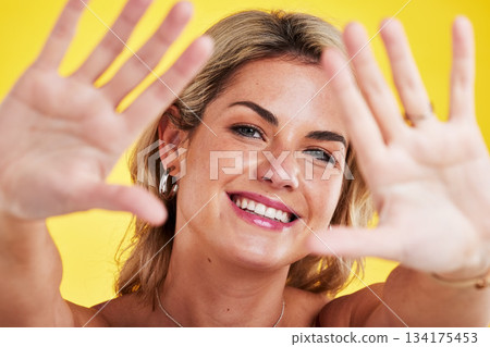 Fashion, frame and portrait of woman with hands on yellow background in makeup, natural cosmetics and style. Beauty, happiness and face of female person with palms up, confidence and happy in studio 134175453