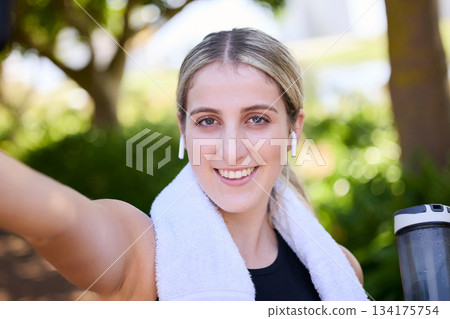 Portrait, happy woman or fitness influencer taking a selfie at training, running or workout in a park. Smile, runner or healthy girl athlete in headphones talking pictures or photo on social media 134175754