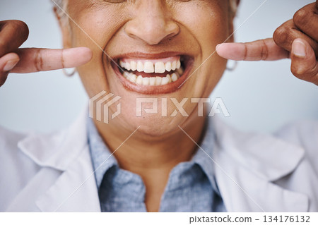 Dental, hand and pointing by elderly woman in studio for mouth, hygiene or denture care on grey background. Teeth whitening, cleaning and senior lady happy for oral, tooth and natural looking veneers 134176132
