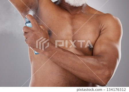 Senior black man, deodorant and spraying armpit for skincare, grooming or personal hygiene against a gray studio background. Elderly African American male applying cosmetics for fresh or clean smell 134176312