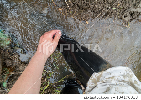 用稻田水沖洗沾滿插秧泥土的靴子。 134176318