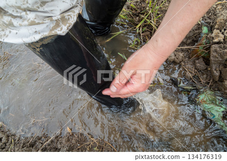 用稻田水沖洗沾滿插秧泥土的靴子。 134176319