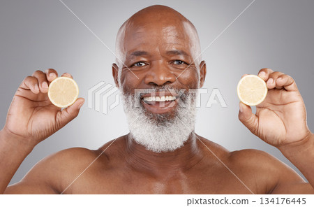 Senior black man, portrait and fruit for vitamin C, skincare or natural nutrition against gray studio background. Happy African American male smile and citrus lemon for healthy skin, diet or wellness 134176445