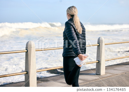 Stretching legs, fitness and a woman at the beach for running, exercise and getting ready for cardio. Back, ocean and a runner preparing to train for sport or an outdoor workout with a warm up 134176485