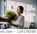 A Japanese woman smiles happily after receiving mimosa flowers 134176580