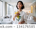 A Japanese woman smiles happily after receiving mimosa flowers 134176585