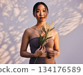 Smiling Japanese woman holding mimosa flowers 134176589