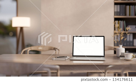 Blank screen laptop with coffee cup aside pencil on notebook and vase on wooden table in living room Blank screen laptop with coffee cup aside pencil on notebook and vase on wooden table in living room 134176611