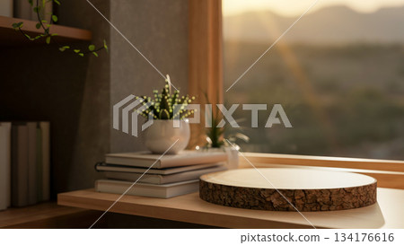 Wooden tree stump coaster and potted plant over book on wooden table aside window with warm sunlight Wooden tree stump coaster and potted plant over book on wooden table aside window with warm sunlight 134176616