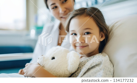 Woman in yellow sweater checks grocery shopping list while pushing cart filled with fresh vegetables and fruits in a supermarket aisle, showcasing organized shopping experience 134177232