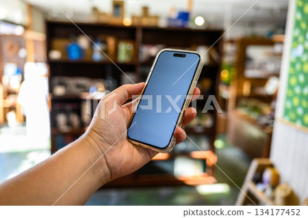 在雜貨店裡拿著手機 134177452