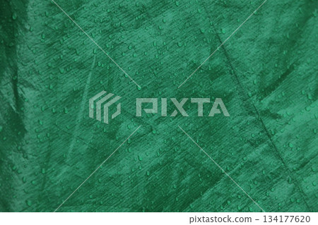 Green waterproof fabric texture covered in rain droplets background Green waterproof fabric texture covered in rain droplets background 134177620