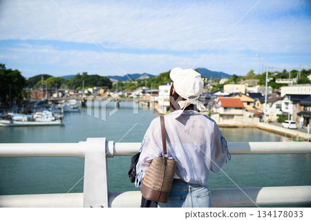 Woman overlooking the port town 134178033
