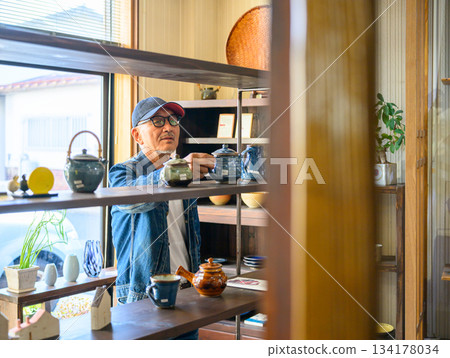Choosing pottery at a general store 134178034