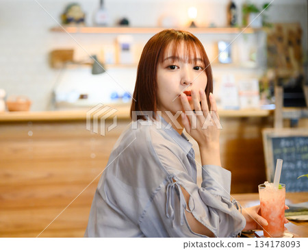 Woman enjoying a drink at a cafe Woman enjoying a drink at a cafe 134178093