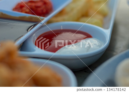 Close up of white dipping dish filled with classic ketchup and mayonnaise sauce. 134178142